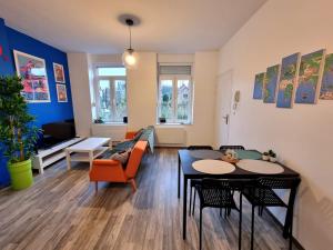 a living room with a couch and a table at La Maison Jaurès - Le Nintendo in Liévin