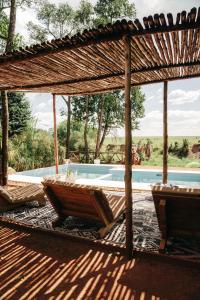 eine Terrasse mit 2 Stühlen und einem Pool in der Unterkunft Emboo River Camp in Talek