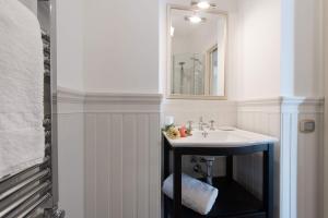 a bathroom with a sink and a mirror at DUOMO SEA SIDE DELUXE APARTMENT by Ortigiaapartments in Siracusa