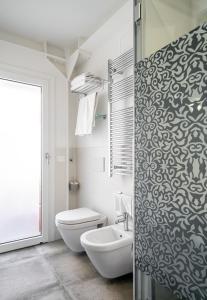 a white toilet sitting next to a bathroom sink at Hotel Lampara in Lignano Sabbiadoro