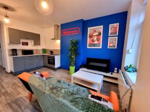 a living room with a couch and a kitchen at Le Nintendo in Liévin
