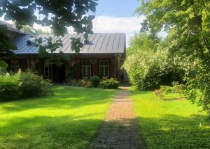 a house with a brick path in front of a yard at Willa "Mazowsze" in Nałęczów