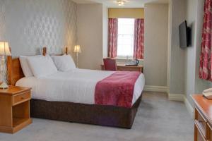 a hotel room with a large bed and a window at Old Hunstanton Le Strange Arms Hotel in Hunstanton