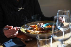 eine Person, die an einem Tisch mit einem Teller Essen sitzt in der Unterkunft Ô Chiroulet - Le Refuge de l'Isard in Bagnères-de-Bigorre