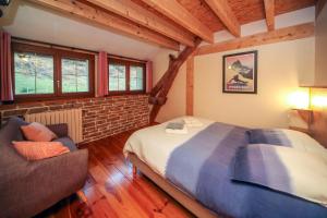 ein Schlafzimmer mit einem Bett und einem Sofa in einem Zimmer in der Unterkunft Ô Chiroulet - Le Refuge de l'Isard in Bagnères-de-Bigorre