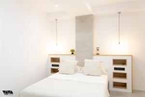 ein Schlafzimmer mit einem weißen Bett mit weißen Wänden in der Unterkunft GR04 in Alicante