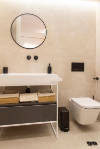 ein Badezimmer mit einem Waschbecken, einem WC und einem Spiegel in der Unterkunft GR04 in Alicante
