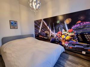 a bedroom with a video game mural on the wall at Le Nintendo in Liévin