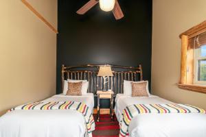 two beds in a room with black walls at The Alpine Lodge in North Creek