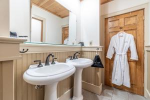 a bathroom with two sinks and a wooden door at The Alpine Lodge in North Creek