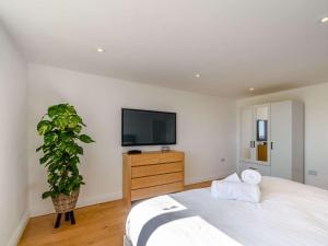 a bedroom with a large bed and a tv on the wall at 2-Bed Modern Bungalow - Outstanding Country Views in Harrogate