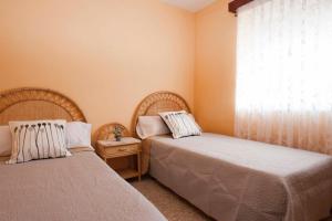 two beds sitting in a room with a window at Casa Rural Carricola in Carrícola