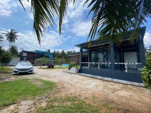 a house with a car parked in front of it at Baan Suriya Sichon in Ban Thepha