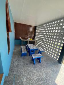 Habitación con 2 bancos azules y una mesa. en Baan Suriya Sichon en Ban Thepha