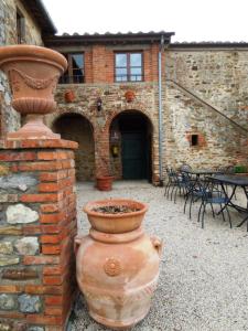 a large vase sitting next to a brick wall at Villa Cenerentola in Trequanda