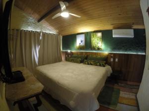 um quarto com uma cama num pequeno quarto em Pousada Paraíso Açú em Itaipava