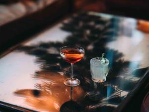 a glass of wine sitting on a table with a drink at Soho Grand Hotel in New York