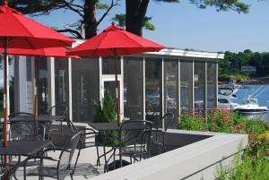 約克的住宿－碼頭遊客區酒店，一个带桌椅和红伞的庭院