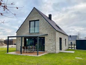 ein Backsteinhaus mit einem Tisch im Hof in der Unterkunft Ferienhaus Seeblick am Harkebrügger See mit Sauna und Kamin in Barßel