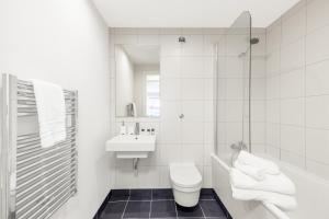 a white bathroom with a toilet and a sink at Impeccable 1-Bed Apartment in London City in London