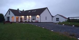 a white house with lights on the front of it at Puffin rooms in Lisdoonvarna