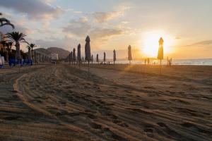 einen Sandstrand mit Sonnenschirmen und dem Meer in der Unterkunft GR04 in Alicante