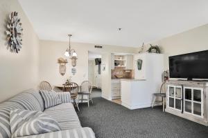 a living room with a couch and a table with chairs at Tucked Away in the Sand in Indialantic