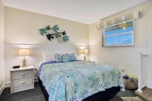 a white bedroom with a bed and a window at Tucked Away in the Sand in Indialantic +15 photos