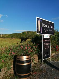 a sign in a field with a barrel and a sign at Puffin rooms in Lisdoonvarna