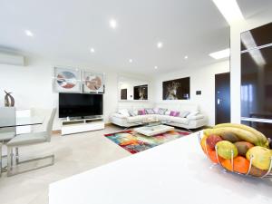 een witte woonkamer met een fruitschaal op de vloer bij Luxury condominium apartment with swimming pool #1903 in Lagos