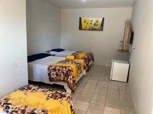 a room with three beds in a room at Pousada Do Sol in Parnaíba