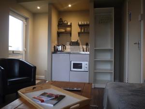 a living room with a table and a kitchen at Rodeen self-catering apartment in Castletownbere