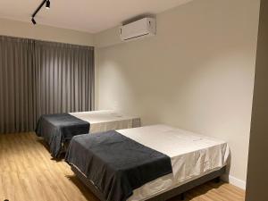 um quarto de hospital com duas camas e ar condicionado em Locking's Santo Agostinho 2 em Belo Horizonte