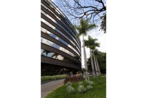 a building with a palm tree in front of it at Locking's Santo Agostinho 2 in Belo Horizonte