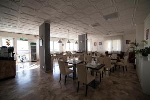 uma sala de jantar com mesas e cadeiras e um bar em Riviera Mare Beach Life Hotel em Rimini