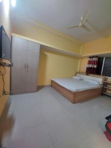 a bedroom with a bed and a flat screen tv at Alpine Green in Rānchī