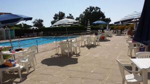 a group of tables and chairs next to a swimming pool at Appartamento presso Residence Erice Beach - Casa Vacanza in Erice +18 photos