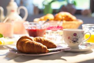 einen Tisch mit einem Teller Croissants und einer Tasse Kaffee in der Unterkunft Pension Margarete in Handthal