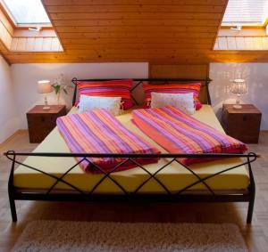 ein Bett mit bunten Decken in einem Zimmer in der Unterkunft Pension Margarete in Handthal