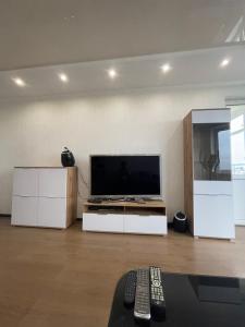uma sala de estar com uma televisão de ecrã plano e armários brancos em View Apartments, 22 floor with 2 rooms em Kiev