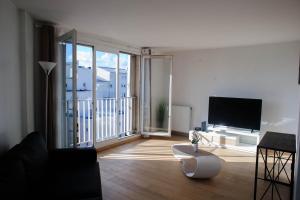 a living room with a television and a balcony at Créteil. Au pied du lac. T4 de 67 m2 in Créteil