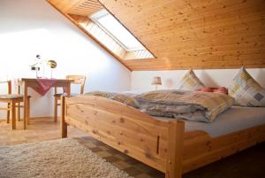 Schlafzimmer mit einem großen Holzbett und einem Dachfenster in der Unterkunft Pension Margarete in Handthal