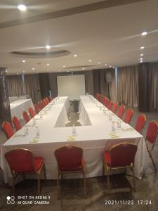 a long table in a room with chairs and a screen at Le Grand Hotel d'Abidjan in Abidjan