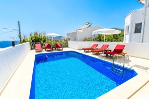 een zwembad met rode stoelen naast een huis bij Villa White Dream in Kalkan