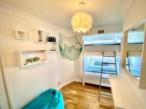 um pequeno quarto com beliches e um lustre em Gulliver's Cottage in Frinton-On-Sea em Frinton-on-Sea