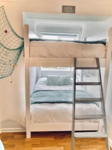 a bunk bed in a small room with a ladder at Gulliver's Cottage in Frinton-On-Sea in Frinton-on-Sea