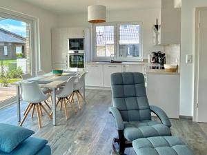 a kitchen and dining room with a table and chairs at Ferienhaus Seestern am Harkebrügger See mit Sauna und Kamin in Barßel