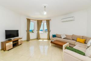 een woonkamer met een bank en een tv bij Villa White Dream in Kalkan