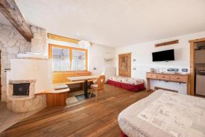 a bedroom with a room with a fireplace and a bed at La pratolina monolocale in Castello di Fiemme
