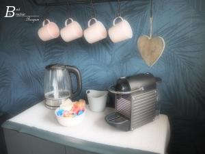 a counter with a coffee maker and cups on it at Bed & Brochje Burgum in Burgum